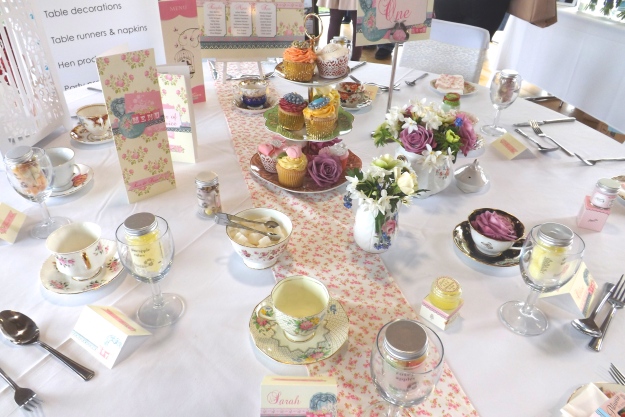 Ditsy fabric table runners with matching napkin wraps an an old English feel to the tables. Vintage crockery mixed with candy sweets jars bring this vintage tea look together.
